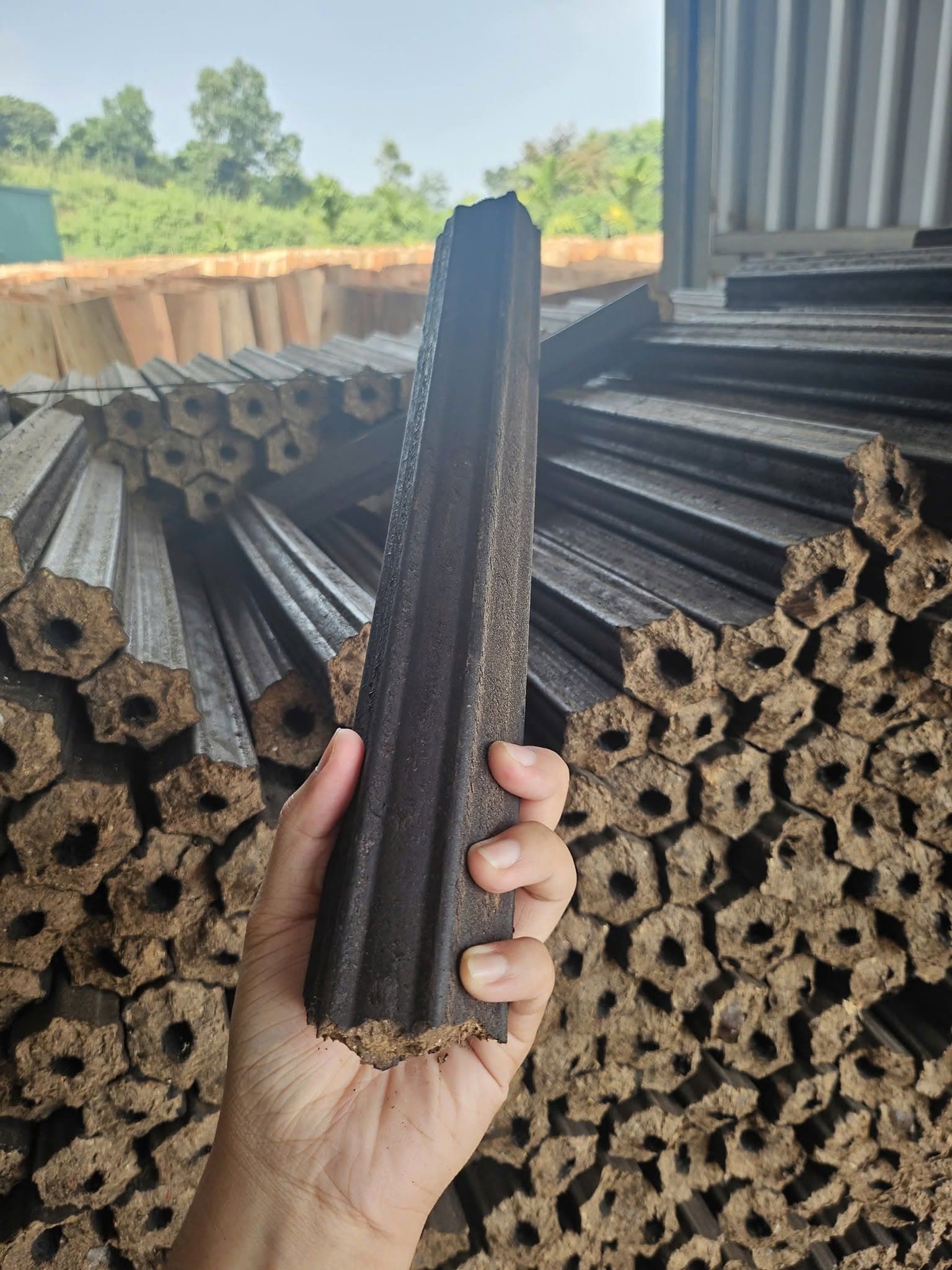 Hexagonal sawdust charcoal briquette rods with a hole through the centre